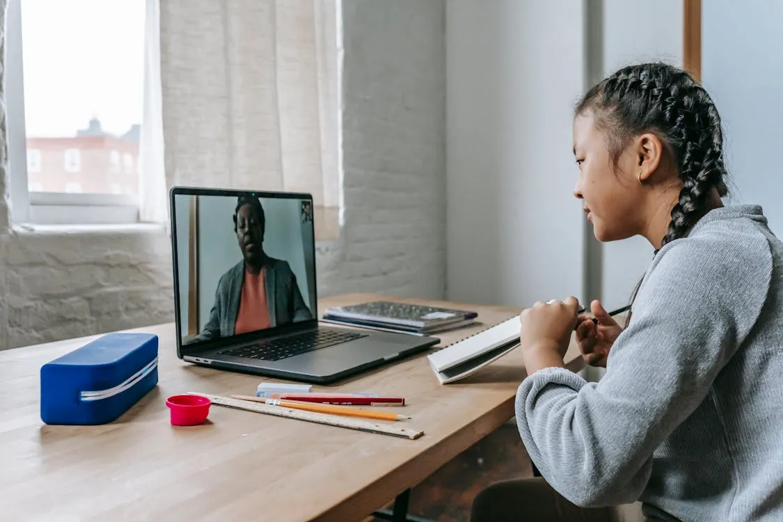 A student focused on her online math lesson with teacher